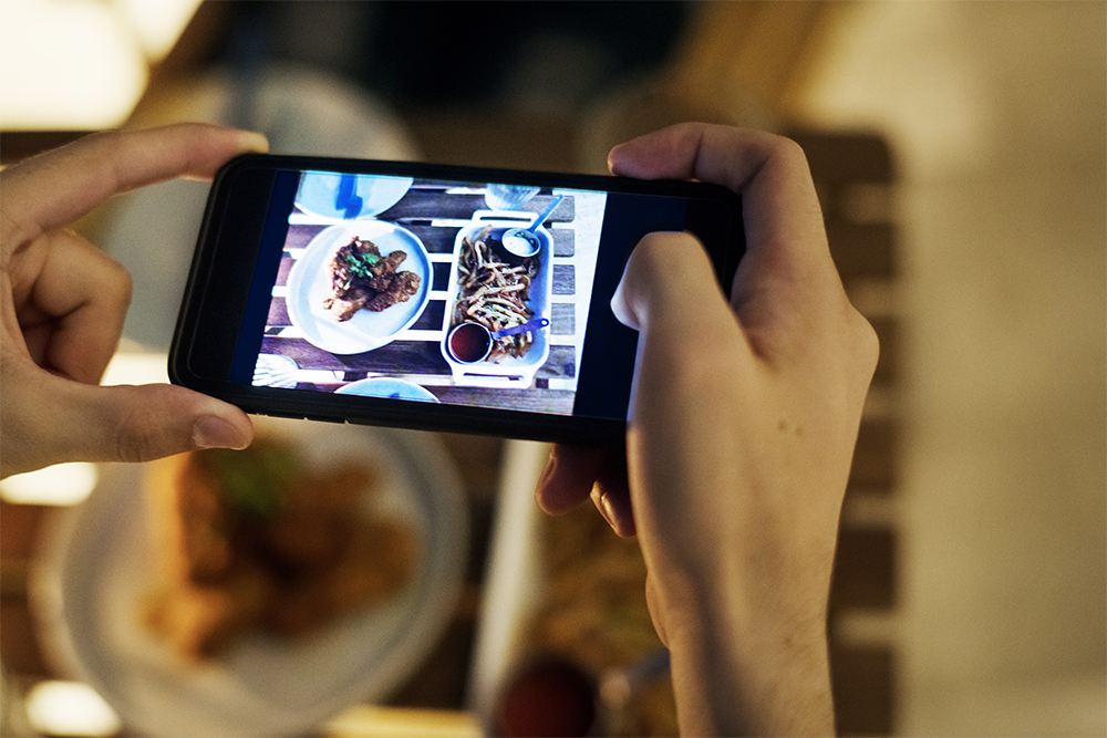 taking smartphone photo of a dinner plate social P4K6ZUJ 4