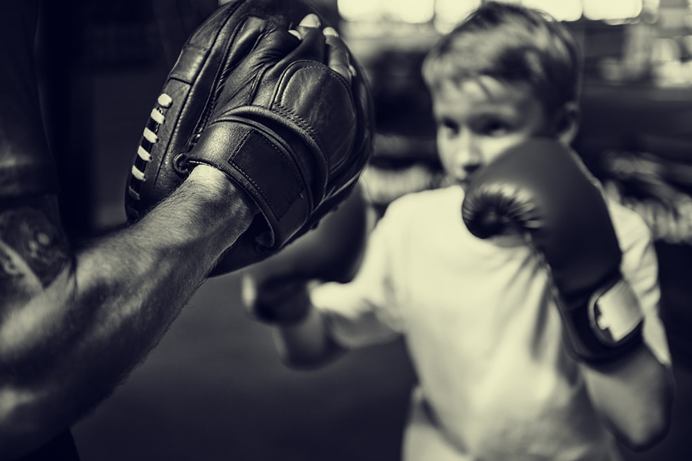 boy boxing training punch mitts exercise concept PFHMF6Y 2 4