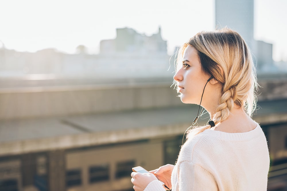 young beautiful caucasian woman listening to PM4H5TD 4 แกะรอยความสำเร็จของ Spotify เบอร์หนึ่งของโลกแห่งเสียงเพลง